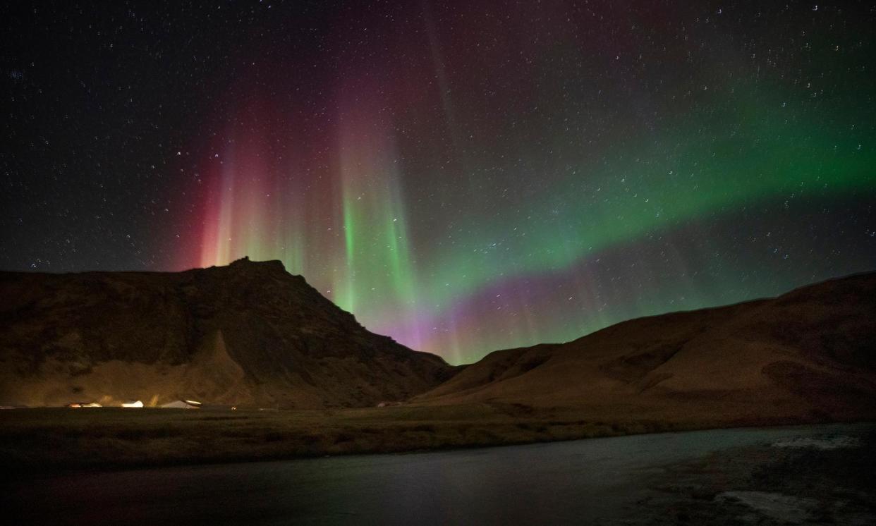 <span>The aurora borealis fills the sky over Skógafoss waterfall on the Skógá River in the south of Iceland in March.</span><span>Photograph: Owen Humphreys/PA</span>