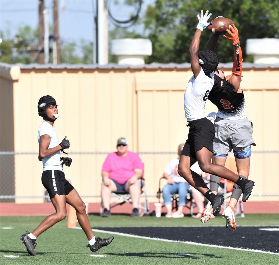 A Wink player, right, fights a TLCA-San Angelo player for a pass during pool play at the Abilene Division III 7-on-7 state qualifying tournament on Friday, June 10, 2022, at McMurry's Wilford Moore Stadium.