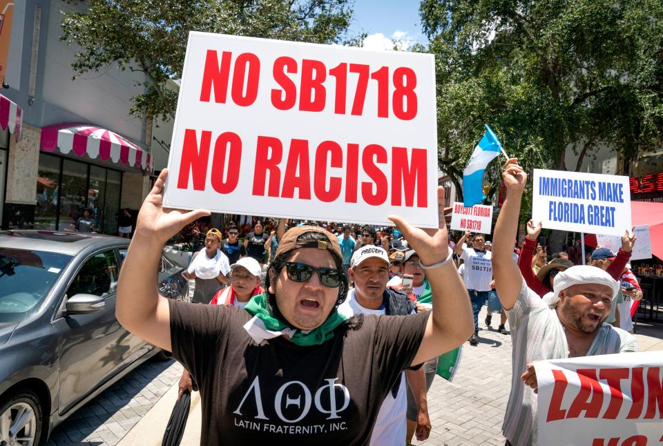 Ricardo Martinez, left, marches with other to protest the controversial new immigration law, SB 1718, that was signed into law by Florida Gov. Ron DeSantis. Hundreds gathered and marched in downtown West Palm Beach, Florida on June 1.