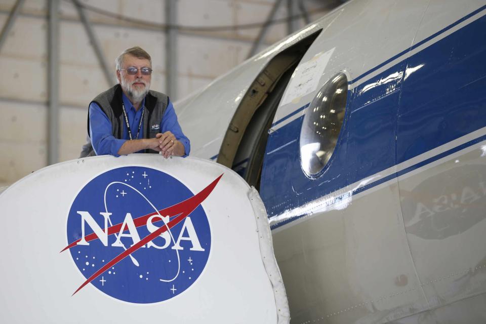 NASA scientist William Krabill stands outside of a NASA P-3 plane at the NASA Wallops flight facility on Wallops Island