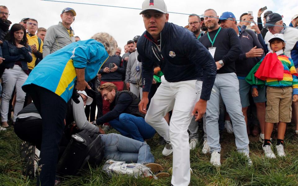 Brooks Koepka of the US gives a dedicated golf glove to spectator he wounded when his ball hit her on the 6th hole during his fourball match on the opening day of the 42nd Ryder Cup  - AP