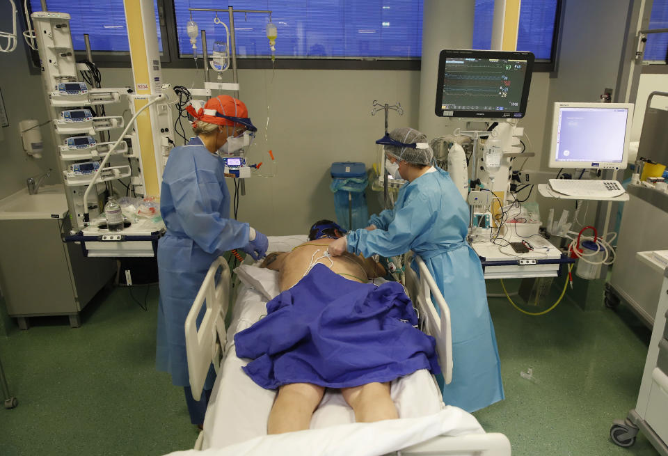 Medical staff members tend to a patient in the COVID-19 Intensive Care Unit of the Papa Giovanni XIII hospital in Bergamo, Italy, Thursday, March 18, 2021. Bergamo’s state-of-the-art Pope John XXIII Hospital verged on collapse last March: as army trucks ferried virus dead from the city’s over-taxed crematoria, doctors struggled to care for 600 COVID patients, 100 in intensive care. One year later, the picture is much improved: the hospital now is treating fewer than 200 virus patients, just one quarter of those requiring intensive care. (AP Photo/Antonio Calanni)