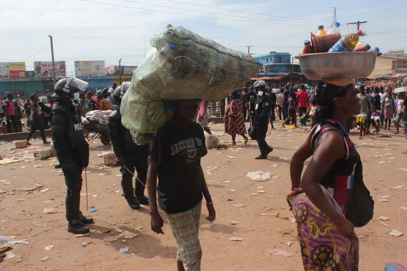 Police officers chase shoppers to clear the streets of the Red Light market on the first day of lockdown to stop the spread of the coronavirus disease (COVID-19) in Monrovia