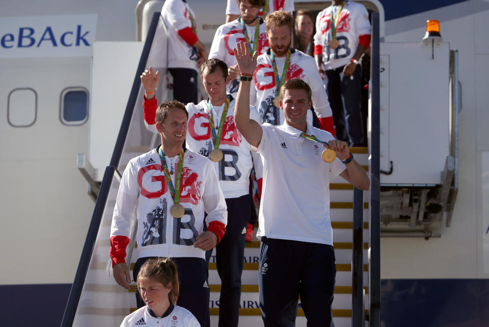 Great Britain's Pete Reed wears his gold medal as he arrives at Heathrow Terminal 5.