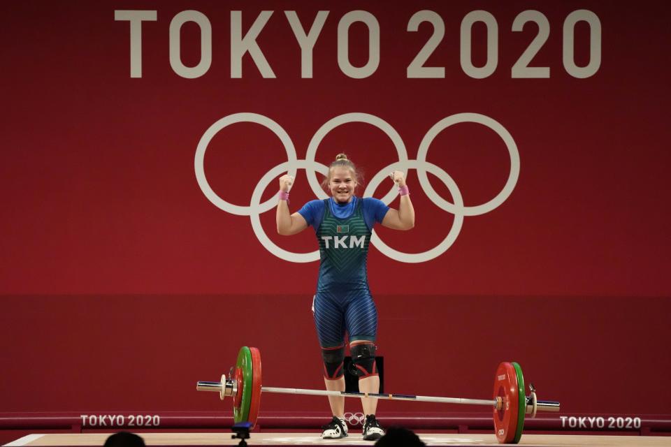 Polina Guryeva of Turkmekistan celebrates after a lift as she competes in the women's 59kg weightlifting event, at the 2020 Summer Olympics, Tuesday, July 27, 2021, in Tokyo, Japan. (AP Photo/Luca Bruno)