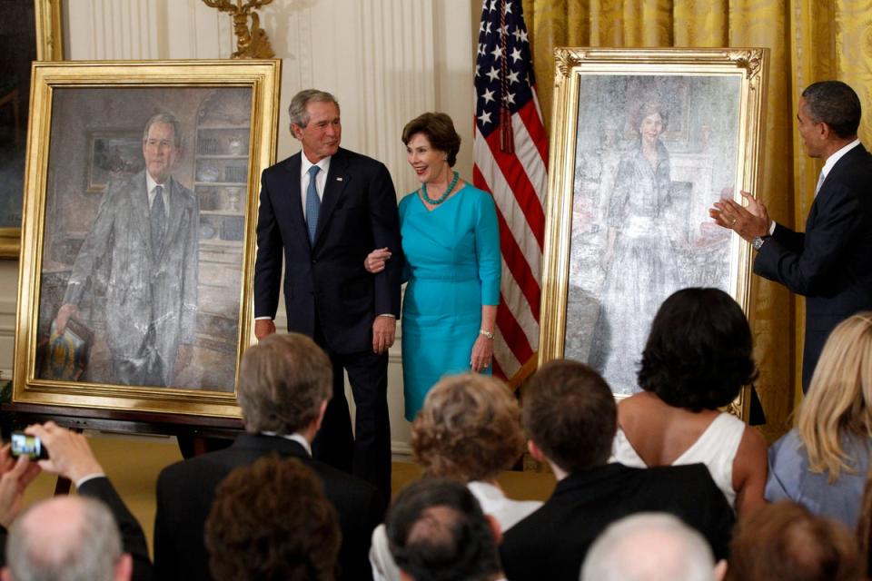 Barack Obama aplaude mientras George W. Bush y su esposa Laura ven sus retratos añadidos a la colección de la Casa Blanca el 31 de mayo de 2012 (AP)
