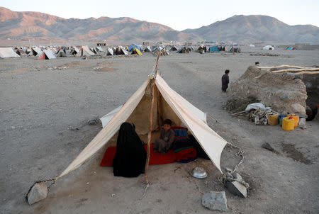 Internally displaced Afghan family sits inside a tent at a refugee camp in Herat province, Afghanistan October 14, 2018. Picture taken October 14, 2018. REUTERS/Mohammad Ismail