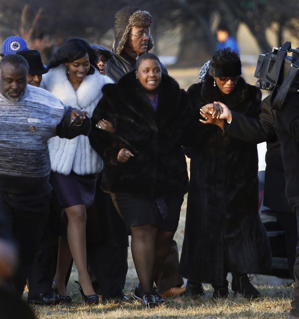 FILE - In this Feb. 9, 2013 file photo, Cleopatra Pendleton, center, is escorted to the gravesite of her daughter, 15-year-old Hadiya Pendleton, during funeral services at the Cedar Park Cemetery in Calumet Park, Ill. Pendleton was was shot and killed Jan. 29, 2013 in a park during a gang dispute she had nothing to do with about a mile from President Barack Obama’s Chicago home. Since Pendleton's death a year ago, homicide and other violent crimes have fallen sharply as police and the city have changes strategies. (AP Photo/Charles Rex Arbogast, File)