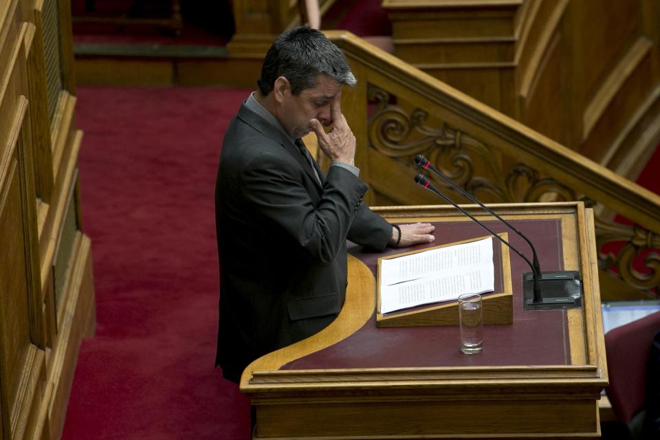 Greek lawmaker Efstathios Boukouras, whom the Golden Dawn party expelled this year and one of five party lawmakers jailed pending trial for allegedly running a criminal organization, pauses during a tearful speech in Parliament in Athens, on Wednesday, May 7, 2014. Lawmakers voted Wednesday to lift the immunity from prosecution of Boukouras, two Golden Dawn lawmakers and a fourth lawmaker who has left the party, to face charges linked with a judicial crackdown on the Nazi-inspired Golden Dawn party. (AP Photo/Petros Giannakouris)