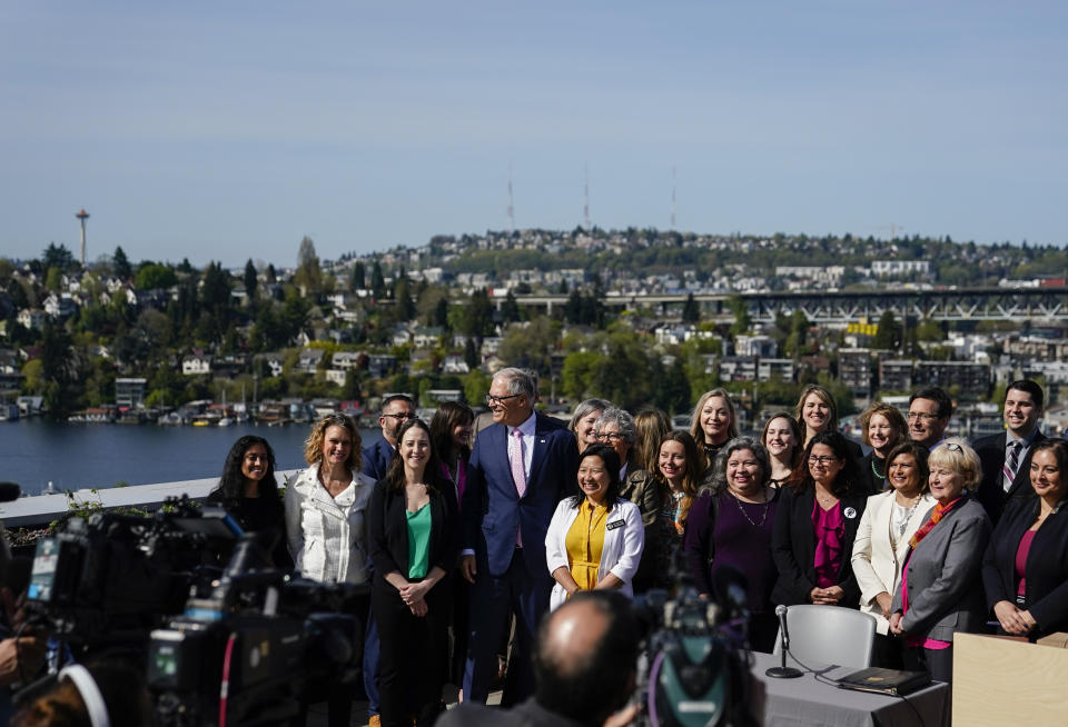 Washington Gov. Jay Inslee, center, poses with officials and supporters after signing several bills aimed at protecting reproductive health and gender-affirming care in Washington, Thursday, April 27, 2023, at the University of Washington's Hans Rosling Center for Population Health in Seattle. (AP Photo/Lindsey Wasson)