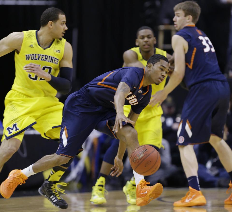 Illinois guard Jaylon Tate (1) drives the ball against Michigan defense in the first half of an NCAA college basketball game in the quarter finals of the Big Ten Conference tournament Friday, March 14, 2014, in Indianapolis. (AP Photo/Michael Conroy)