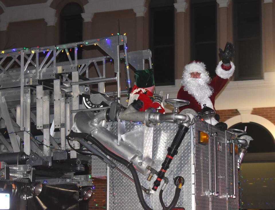 Santa Claus is pictured in Adrian's annual Holiday Lights parade Dec. 2, 2022, waving from the Adrian Fire Department ladder truck's bucket.