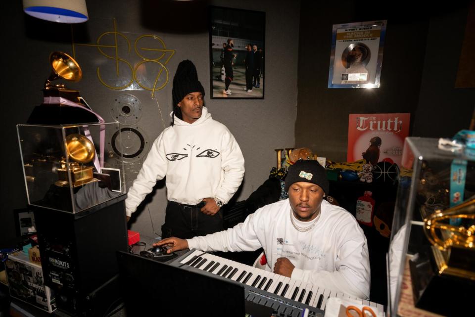 Two men in the studio with Grammys in the foreground.