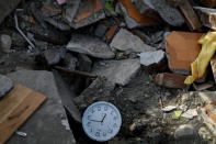 A stopped clock, showing the time a few minutes after the earthquake, lies among rubble in Balaroa neighbourhood hit by an earthquake and ground liquefaction in Palu, Central Sulawesi, Indonesia, October 7, 2018. REUTERS/Jorge Silva