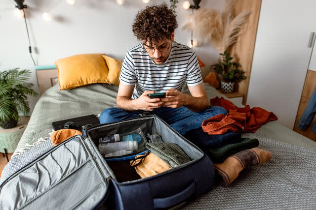<p>Getty Images</p> College student packing and getting phone up to date