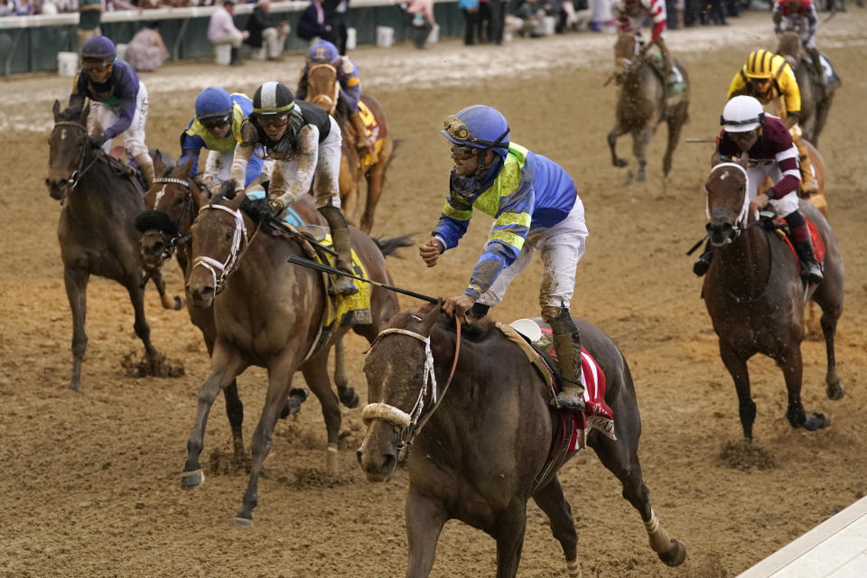 Luis Saez rides Secret Oath, center front, across the finish line to win the 148th running of the Kentucky Oaks horse race at Churchill Downs Friday, May 6, 2022, in Louisville, Ky. (AP Photo/Jeff Roberson)