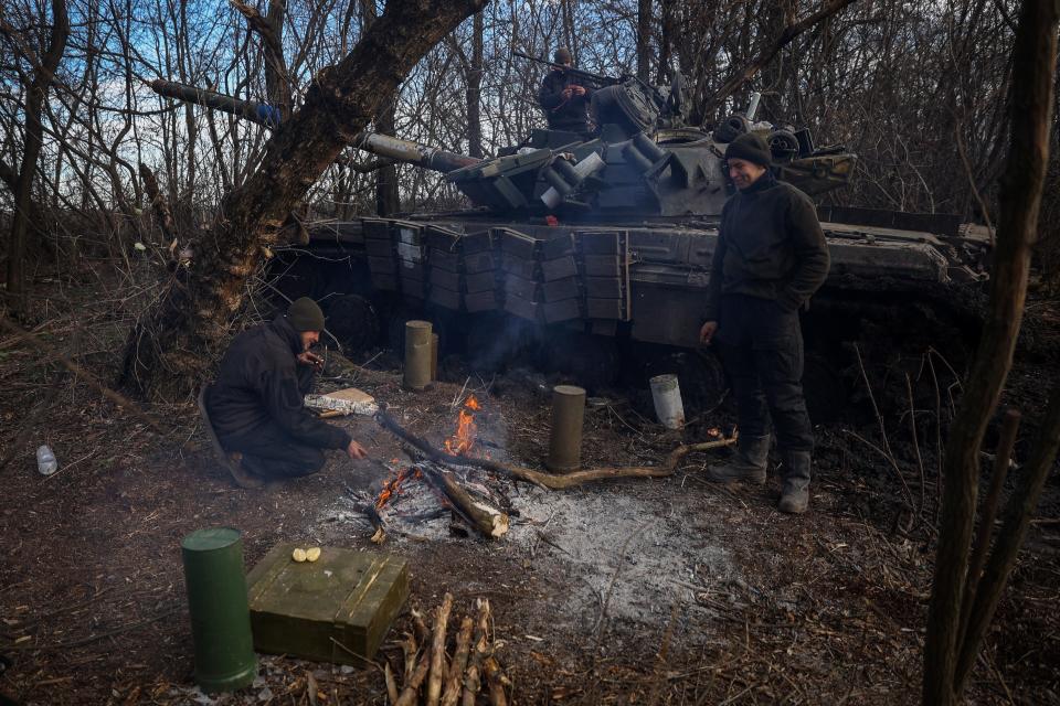 Ukrainian servicemen warm themselves next to their tank at a position near Bakhmut, Donetsk region (AFP via Getty Images)