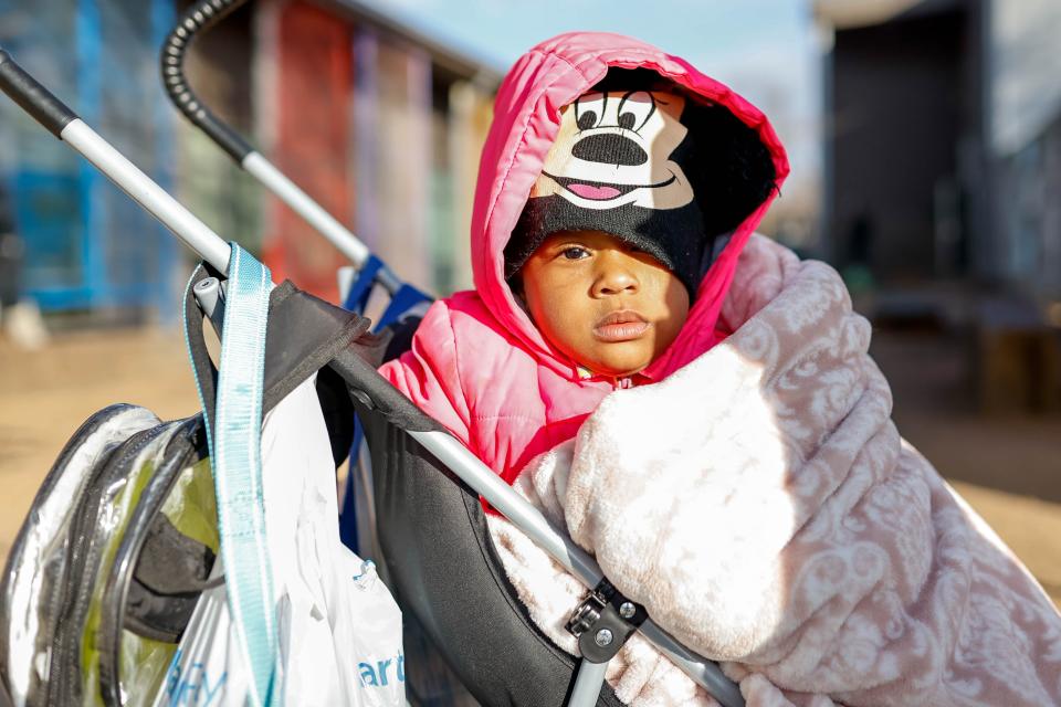 Alani Harris waits for a bus to the night shelter with her sisters and mother on Jan. 13 at the Homeless Alliance day shelter in Oklahoma City.