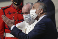 Pope Francis is greeted by Iraqi Prime Minister Mustafa al-Kadhimi upon his arrival at Baghdad's international airport, Iraq, Friday, March 5, 2021. Pope Francis heads to Iraq on Friday to urge the country's dwindling number of Christians to stay put and help rebuild the country after years of war and persecution, brushing aside the coronavirus pandemic and security concerns. (AP Photo/Andrew Medichini)