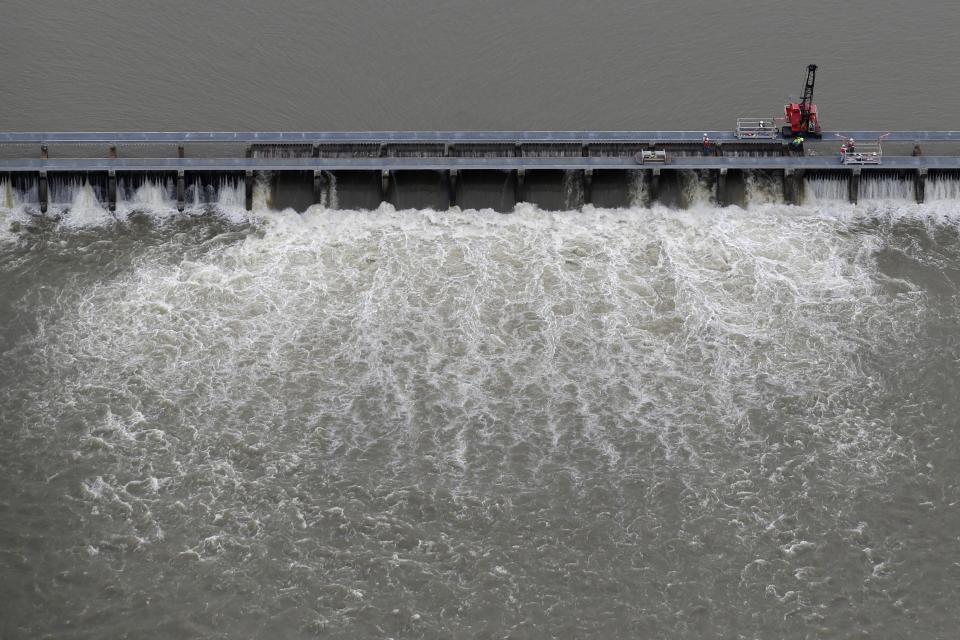 FILE- In this May 10, 2019 file photo, workers open bays of the Bonnet Carre Spillway, to divert rising water from the Mississippi River to Lake Pontchartrain, upriver from New Orleans, in Norco, La. It will be months before state officials know whether losses from floods and spillway openings qualify Louisiana as a fisheries disaster. Department of Wildlife and Fisheries officials say floods began around November 2018, and a full 12 months' data is needed to compare to averages for the previous 5 years. The governors of Louisiana, Mississippi and Alabama asked months ago for US Commerce Secretary Wilbur Ross to declare a fisheries disaster, making federal grants available to affected people. (AP Photo/Gerald Herbert, File)