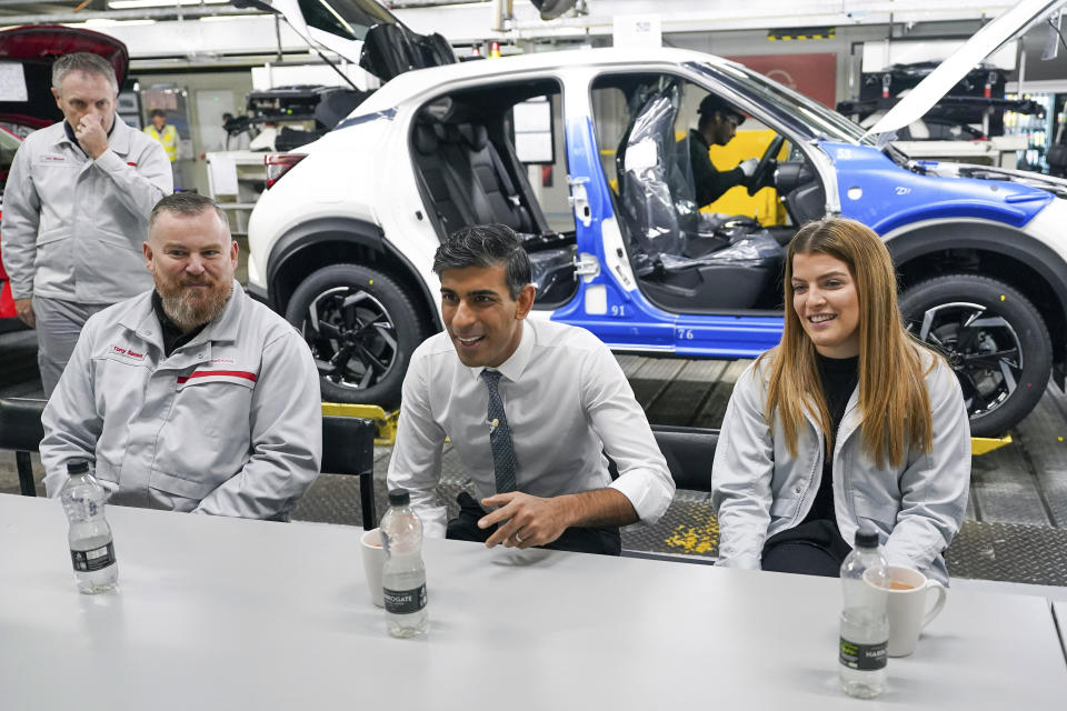 Britain's Prime Minister Rishi Sunak, centre speaks to employees during a visit to the car manufacturer Nissan, in Sunderland, England, Friday, Nov. 24, 2023. Nissan will invest more than $1.3 billion to update its factory in northeast England to make electric versions of its two best-selling cars. It's a boost for the British government as it tries to revive the country’s ailing economy. The Japanese automaker manufactures the gasoline-powered Qashqai and smaller Juke crossover vehicles at the factory in Sunderland, which employs 6,000 workers. (Ian Forsyth/Pool Photo via AP)