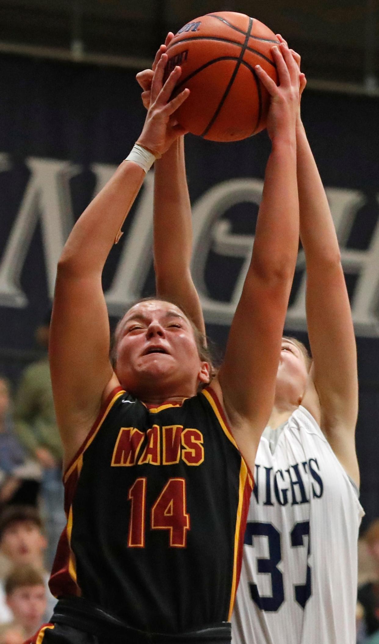 McCutcheon Mavericks guard Aubrey Miller (14) and Central Catholic Knights Casey Schuessler (33) fight for a rebound during the IHSAA girl’s basketball game, Tuesday, Dec. 5, 2023, at Central Catholic High School in Lafayette, Ind. McCutcheon Mavericks won 48-42.