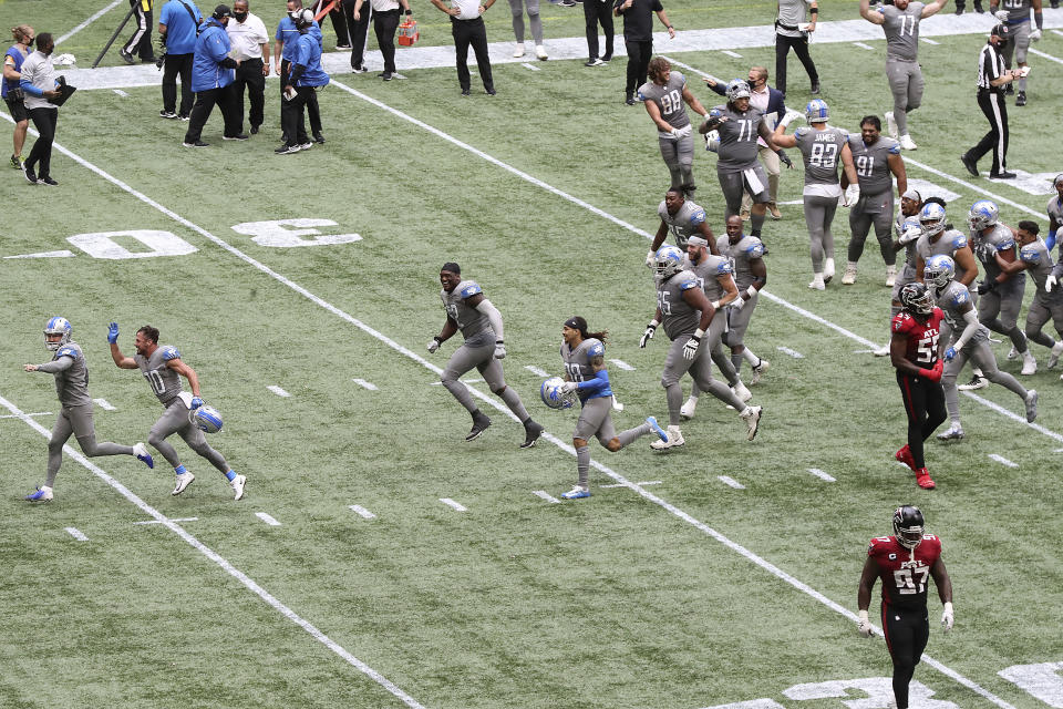 Detroit Lions kicker Matt Prater, far left, is chased off the field by celebrating teammates after making the extra point attempt to defeat the Atlanta Falcons as time expired in an NFL football game while Falcons players Grady Jarrett, bottom right, and Steven Means walk off the field Sunday, Oct. 25, 2020, in Atlanta. (Curtis Compton/Atlanta Journal-Constitution via AP)