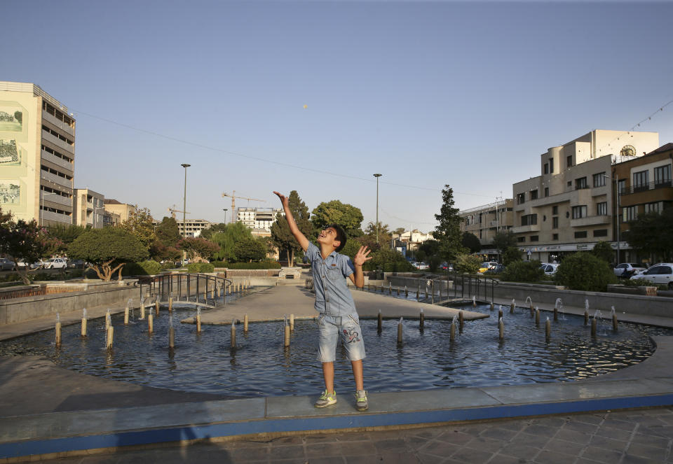 In this Friday, Aug. 17, 2018 photo, a boy plays in Baharestan Square, a scene of clashes during the 1953 U.S.-backed coup in downtown Tehran, Iran. In 2018, as Iran deals with President Donald Trump's decision to pull America from the nuclear deal with world powers, more are invoking the 1953 CIA-backed coup that toppled Mossadegh as proof the U.S. cannot be trusted. (AP Photo/Vahid Salemi)