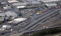 In this Aug. 2, 2014 aerial photo, trains with cargo containers are shown south of Seattle. More than two dozen major companies ranging from Campbell Soup to Kia filed anti-trust lawsuits on Sept. 30, 2019 against the nation's four largest railway companies, contending the railroads had a price-fixing scheme to illegally boost profits. (AP Photo/Ted S. Warren)