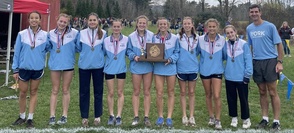 Members of the York High School girls cross country team celebrate after the Wildcats won their second straight Class B state championship on Saturday in Belfast, Maine.