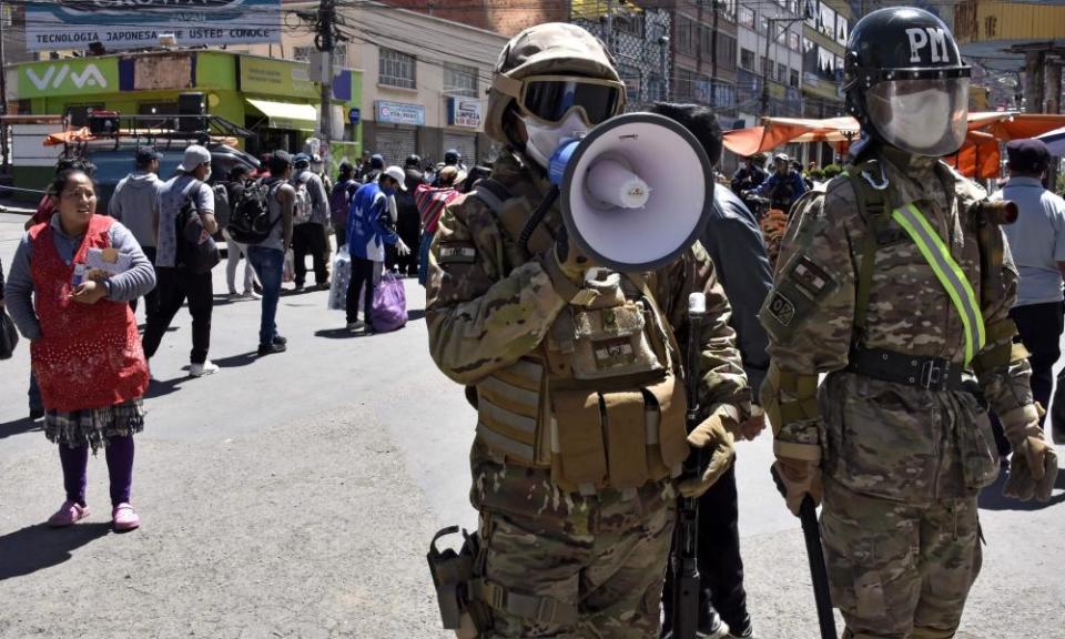 A military policeman uses a loudspeaker to tell people to go home during a total lockdown in El Alto, Bolivia, on 3 April.