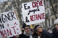 Protesters carry posters, one reading "Striking until I retire" during a demonstration against plans to push back France's retirement age, Tuesday, Jan. 31, 2023 in Paris. Labor unions aimed to mobilize more than 1 million demonstrators in what one veteran left-wing leader described as a "citizens' insurrection." The nationwide strikes and protests were a crucial test both for President Emmanuel Macron's government and its opponents. (AP Photo/Christophe Ena)