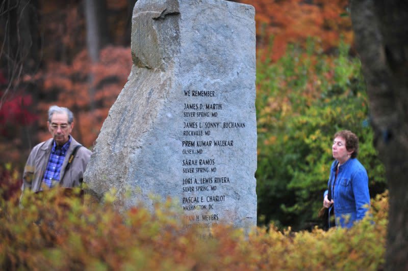 People visit a memorial dedicated to the victims of the 2002 D.C. sniper shootings at Brookside Gardens in Wheaton, Md., on November 10, 2009. On March 10, 2004, Lee Boyd Malvo, 19, was sentenced to life in prison without parole for his role in 10 Washington-area sniper killings in 2002. File Photo by Kevin Dietsch/UPI