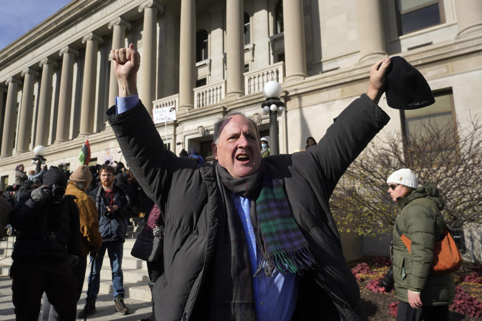 A man stands with arms raised as he reacts to the verdict outside the Kenosha County Courthouse in Kenosha, Wisconsin.