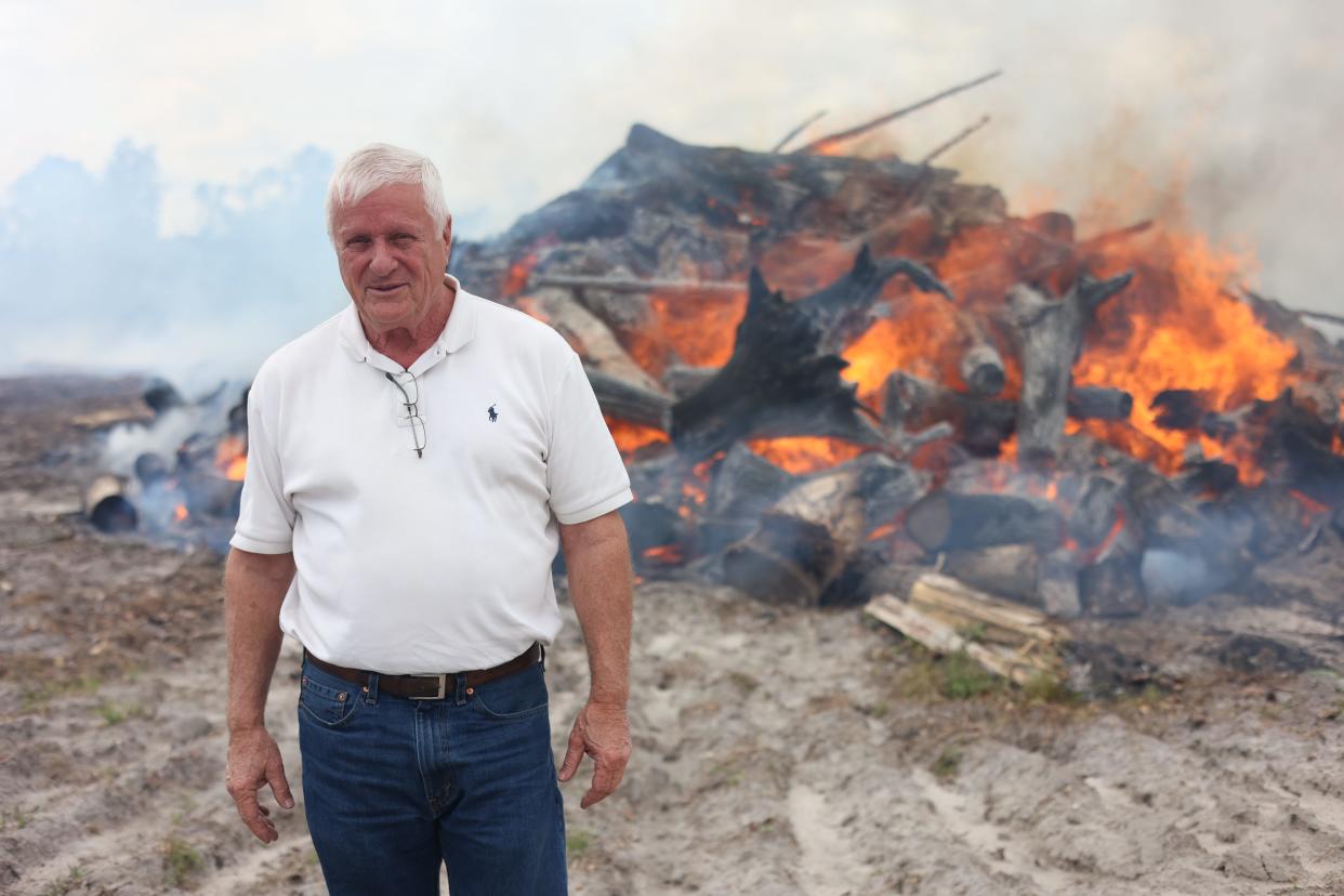 Jody Roberts, a landowner in the timber industry for 50 years, stands in front of a burning pile of pine trees on his 100 acres of land in Taylor County on Tuesday, April 9, 2024.