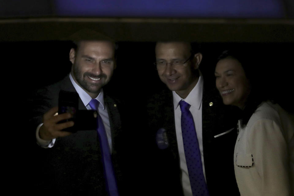 FILE - In this Friday, Feb. 1, 2019 file photo, lawmaker Eduardo Bolsonaro, son of Brazil's President Jair Bolsonaro, left, takes a "selfie" during a swearing-in ceremony, at the National Assembly in Brasilia, Brazil. Brazilian President Jair Bolsonaro says he’s considering nominating his son Eduardo to be ambassador to the United States. Bolsonaro said at a news conference Thursday, July 11, 2019, that nominating his son is, in his words, “something on my radar. (AP Photo/Eraldo Peres, File)