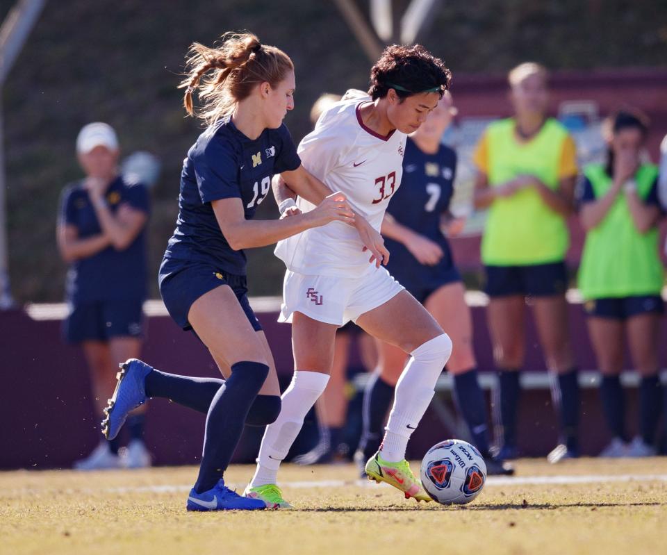 Florida State Seminoles Yujie Zhao (33) battles a defender to keep possession of the ball. Florida State and Michigan remain scoreless at the half during the NCAA quarterfinals Friday, Nov. 26, 2021.