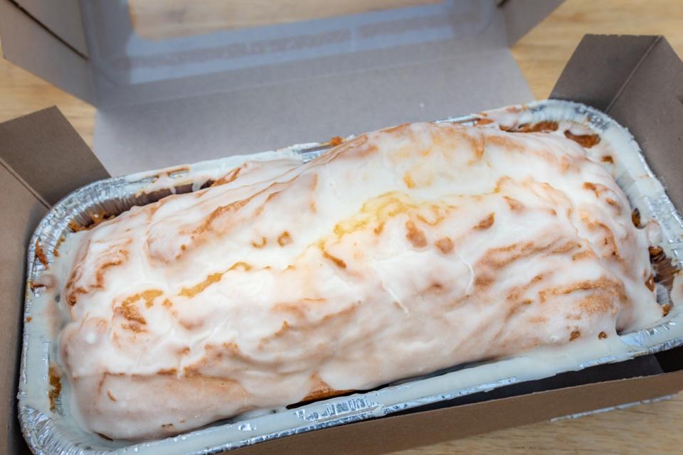 Loaf cake in foil plan topped with white glaze