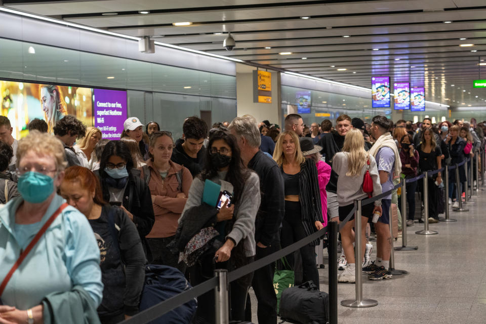 LONDON, ENGLAND - JUNE 01: Travellers wait in a long queue to pass through the security check at Heathrow on June 1, 2022 in London, England. The aviation industry is struggling to recruit staff after waves of layoffs during the Covid-19 pandemic. In the UK, Transport Secretary Grant Shapps said that airlines and operators have 