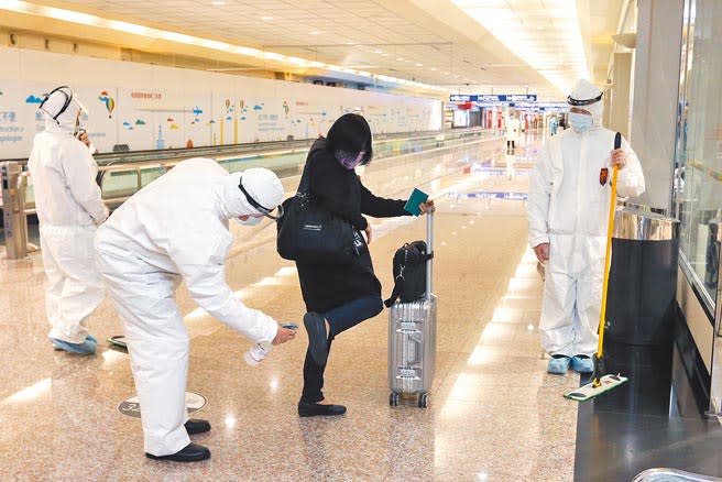 長程航班旅客須在機場採檢陰性，才放行入境，旅客在進入入境長廊前，還需要讓清消人員全身消毒，減少感染病毒機會。（陳麒全攝）