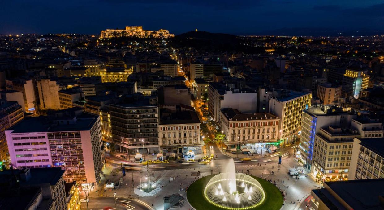 Image: Athens' newly renovated Omonoia square as the Acropolis hill is illuminated in the background, Greece (Aris Messinis / AFP - Getty Images)