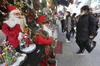 People wearing face masks as a precaution against the coronavirus watch Christmas decorations at a store in Seoul, South Korea, Friday, Nov. 27, 2020. South Korea's daily virus tally hovered above 500 for the second straight day, as the country's prime minister urged the public to stay home this weekend to contain a viral resurgence. (AP Photo/Ahn Young-joon)