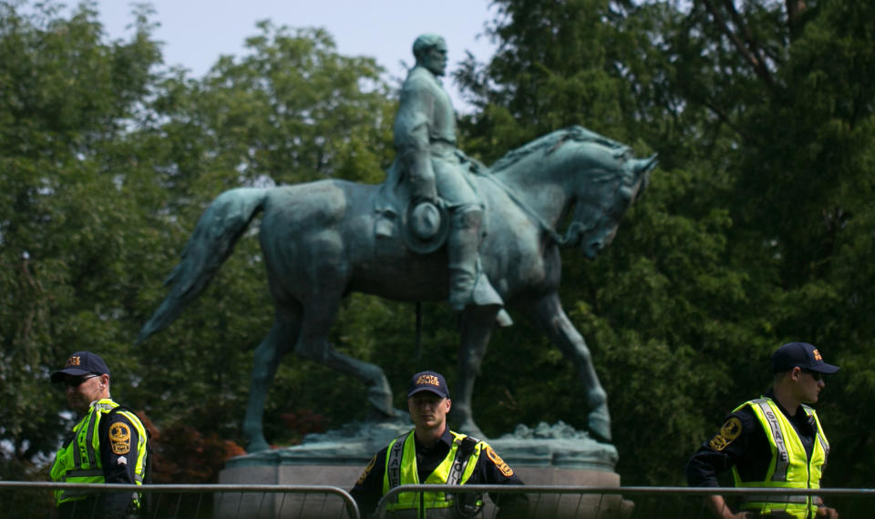 <p>Virginia State Police guard the statue of Confederate Robert E. Lee on August 12, 2018 in downtown Charlottesville, Virginia, on the one-year anniverary of the violent Unite the Right rally that left one person dead and dozens injured. – Last year’s protests in Charlottesville saw hundreds of neo-Nazi sympathizers, accompanied by rifle-carrying men, yelling white nationalist slogans and wielding flaming torches in scenes eerily reminiscent of racist rallies held in America’s South before the Civil Rights movement. (Photo: Logan Cyrus/AFP/Getty Images) </p>