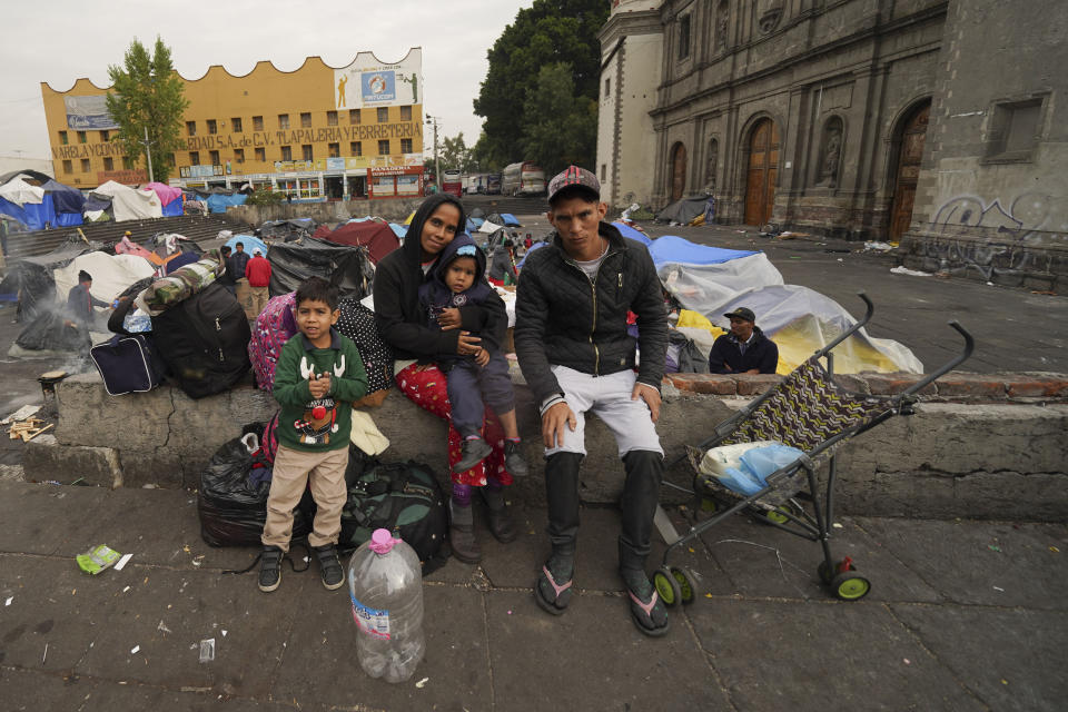 La familia Aguilar Bastida, procedente de Venezuela, fuera de la iglesia de la Santa Cruz y La Soledad, en donde algunos migrantes acampan, el martes 26 de diciembre de 2023, en Ciudad de México. (AP Foto/Marco Ugarte)