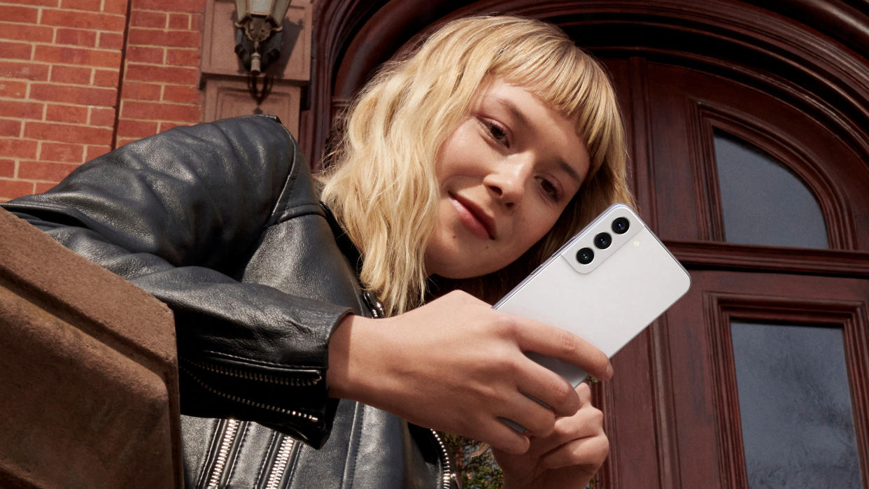  Samsung Galaxy S22 Android phone being held by a woman in a black leather jacket. 