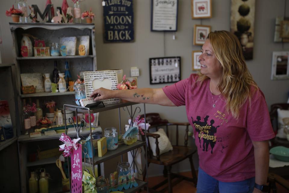 Kelly Gerhardt, co-owner of Past Presents KS, 900 N Kansas Ave. shows what Kansas based vendors have to offer in their areas Thursday afternoon.