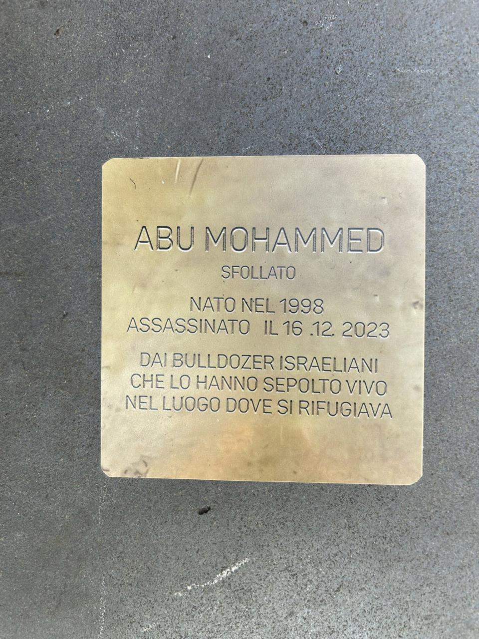 One of the nearly 50 small bronze plaques appears on the sidewalk in front of the offices of the U.N. refugee agency in Rome with the name of a Palestinian killed in Gaza, reads: Abu Mohammed, displaced, murdered by Israeli bulldozers who buried him alive in the place where he took refuge Friday, Jan. 26, 2024. Italy's president on Friday denounced the rise in antisemitism and delivered a powerful speech in support of the Jewish people as he marked a Holocaust Remembrance Day overshadowed by Israel's military campaign in Gaza and a rise in anti-Israel acts here. (AP Photo/Paolo Santalucia)