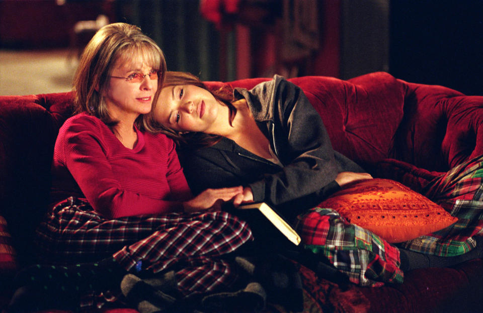 Diane Keaton and Mandy Moore lounge on a couch, one resting her head on the other's shoulder