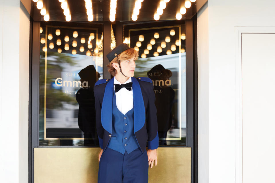 Bellboy standing outside hotel door of Australia's first Sleep Hotel