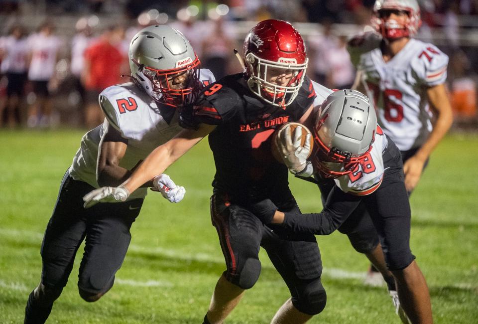 East Union's Carson Sanders (9), center, is tackled by Lincoln's Marquis Williams (2), left, and Tristan Walker (28) during a varsity football game at East Union in Manteca on Friday, Sept. 23, 2022.